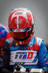 Vincent Stiffel mit Helm und gesenktem Kopf im Fahrerlager